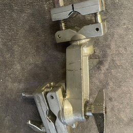 Stříbrný kovový držák s několika šroubovacími mechanismy a dvěma křídlovými maticemi. Povrch vykazuje známky opotřebení v podobě drobných škrábanců a…