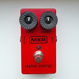 Červený efekt pedál s dvěma černými oválnými ovladači. Na zařízení jsou nápisy OUTPUT, SENSITIVITY, INPUT a v centru logo MXR. Ve spodní části je uve…
