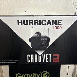 Fotografie znázorňuje kartónovou krabici s černobílým potiskem. Na krabici je uveden název HURRICANE 1000 a logo CHAUVET DJ. Uprostřed je vyobrazen č…