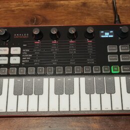 Červený analogový syntetizátor s klaviaturou a ovládacími prvky v horní části. Na pravém horním rohu je logo a nápis SYNTH PRO, vlevo nápisy PARAPHON…