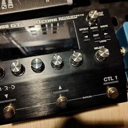 Černý kytarový procesor s kovovým povrchem a nápisem BOSS GT-1000CORE GUITAR EFFECTS PROCESSOR. Zařízení má displej, pět ovládacích knoflíků s čísly…