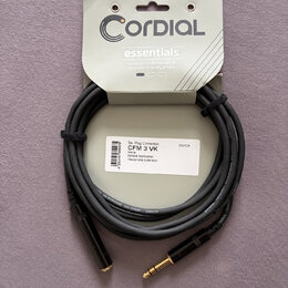 Černý audio kabel s pozlacenými konektory, upevněný na originálním papírovém obalu. Na obalu je nápis CORDIAL essentials a text Versatile fundamental…