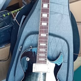 Elektrická kytara typu Les Paul s tmavě modrým průhledným lakem a viditnou strukturou dřeva. Na hlavě je bílé logo Cort, na hmatníku jsou bílé blokov…