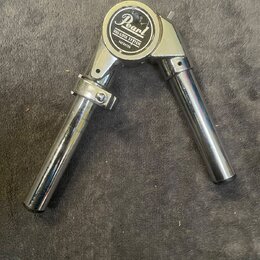 Chromovaný kovový držák na činely s kloubem. Na horním krytu je logo Pearl a nápis UNI-LOCK SYSTEM PATENTED. Povrch vykazuje drobné známky opotřebení…