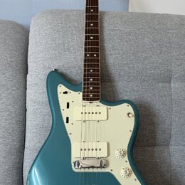 Modrá elektrická kytara s bílým pickguardem a hnědým hmatníkem. Na hlavě je viditelné logo Fender. Kytara má jeden snímač typu humbucker u kobylky a…