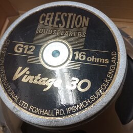Fotografie zachycuje zadní stranu reproduktoru s černým štítkem a stříbrným rámem. Na štítku je uveden nápis CELESTION LOUDSPEAKERS, označení G12 Vin…