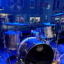 Modrá glimmer bicí souprava značky MAPEX. Sestává z basového bubnu s logem MAPEX, dvou tomů a jednoho floor tomu. Souprava je osazena činely a umístě…