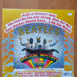 Fotografie zobrazuje obal vinylové desky s nápisem BEATLES a názvem alba MAGICAL MYSTERY TOUR. Na obalu jsou čtyři postavy v kostýmech opic na barevn…