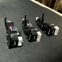 Tři černé gramofonové hlavy s bílými stylosy. Na každé je viditelný nápis Technics a označení modelu M44-7. Na bílých stylosech je nápis SHURE. Všech…