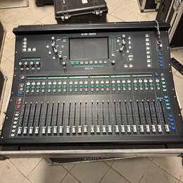 Černý digitální mixážní pult s nápisy ALLEN & HEATH a SQ-6. Zařízení obsahuje dotykový displej, řadu zelených tlačítek a více řad posuvníků. Mixážní…