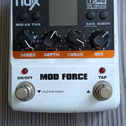 Bílý efekt pedál s nápisem MOD FORCE. Na horní části jsou čtyři černé ovládací knoflíky s popisky SPEED, DEPTH, TWEAK a MIX, displej a nápisy nux, TS…
