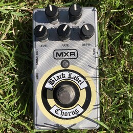 Kytarový efekt pedál stříbrné barvy s kovovým povrchem. Na zařízení jsou nápisy MXR, Black Label Chorus a popisky ovladačů LEVEL, RATE, DEPTH, LOW, H…