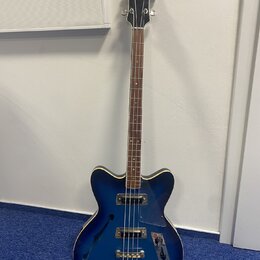Modře gradientní elektrická basová kytara s polodupatým korpusem a hnědým hmatníkem. Na hlavě je bílý nápis „Robin bass“. Nástroj má dva snímače, stř…