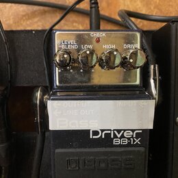 Černý efekt pedál s nápisy Driver BB-1X a logo BOSS. Na horní části jsou čtyři ovládací knoflíky s popisky LEVEL, BLEND, LOW, HIGH a DRIVE a kontrolk…