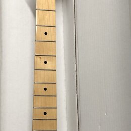Fotografie znázorňuje krk elektrické kytary z ančové barvy dřeva s javorovým hmatníkem. Na hlavě je černý nápis Squier by Fender a TELECASTER DELUXE.…