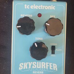 Modře barevný efekt pedál s nápisy tc electronic, SKYSURFER a REVERB. Na horní straně jsou tři černé ovládací knoflíky s popisky REVERB, MIX a TONE,…