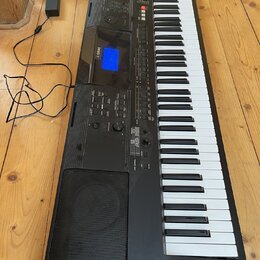 Černý digitální klavír značky YAMAHA s bílými a černými klávesami. Na ovládacím panelu je modře podsvícený displej a nápis YAMAHA. Nástroj je připoje…
