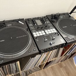Sada černého DJského vybavení skládající se ze dvou kontrolérů a jednoho mixéru. Na obou kontrolérech jsou vidět nápisy serato a rekordbox. Středový…