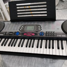 Černý digitální klavír značky CASIO, model CTK-551 s nápisem TOUCH RESPONSE. Nástroj má bílé a černé klávesy, dvě integrovaná kulatáh reproduktory po…