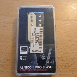 Elektrický snímač typu humbucker v původním plastovém obalu. Na bílém štítku je uveden text „Seymour Duncan ApH-ZN Slash Alnico II Pro ZN Humbucker P…