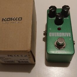 Zelený efekt pedál s nápisem OVERDRIVE a tři černé ovládací knoflíky s popisky DRIVE, LEVEL a TONE. Nad nápisem se nachází malá červená kontrolka. Ve…