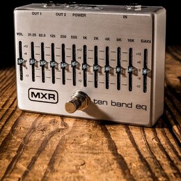 Stříbrný kytarový pedál s nápisem MXR a ten band eq. Zařízení obsahuje deset posuvníků pro ekvalizaci s označením frekvencí od 31.25 do 16K, dále reg…