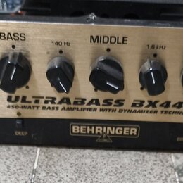 Zlatý basový zesilovač s černými ovládacími knoflíky a analogovým VU metrem vlevo. Na předním panelu jsou nápisy ULTRABASS BX4410, 450-WATT BASS AMPL…