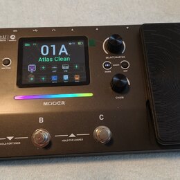 Černý kytarový multi-efekt s integrovaným expresním pedálem. Na zařízení je nápis GE 100 Pro Li AI-Powered Multi-Effects a logo MOOER. Displej zobraz…