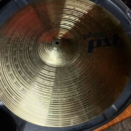 Kovový činel zlaté barvy s koncentrickými rýhami na povrchu. Na pravé straně je modrý nápis pAiste pst 3. Činel je umístěn v černém plastovém obalu.