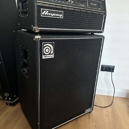 Černý basový kombozesilovač složený z hlavního zesilovače a reproduktorové skříně. Na horním modulu je nápis SVT-450 a logo Ampeg, na spodní skříně j…