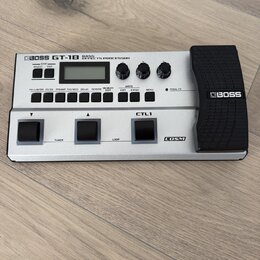 Stříbrný basový efektový procesor značky BOSS, model GT-1B BASS EFFECTS PROCESSOR. Zařízení má digitální displej, několik ovládacích knoflíků a čtyři…