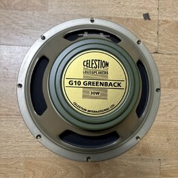 Kruhový reproduktor s kovovým rámem v béžovém odstínu a černou membránou. Uprostřed je žlutý štít s nápisy CELESTION LOUDSPEAKERS, G10 GREENBACK a 30…
