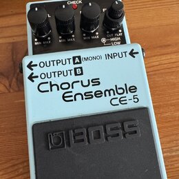 Světle modrý efekt pedál značky BOSS, model Chorus Ensemble CE-5. Na horní části jsou čtyři černé ovládací knoflíky s popisky MIN MAX a CUT FLAT HIGH…