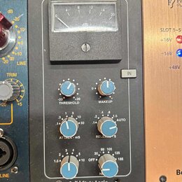 Stupňovitý rackový procesor v šedém kovovém provedení. Na horní hraně jsou nápisy SSL a G COMP, v dolní části nápis Solid State Logic. Zařízení obsah…