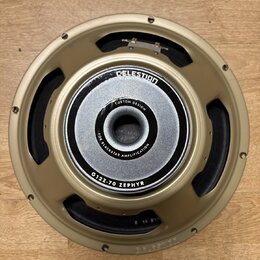 Fotografie znázorňuje reproduktor s kovovým rámem v zlatavé barvě. Na středovém magnetu je bílý nápis CUSTOM DESIGN a FOR BLACKSTAR AMPLIFICATION, po…