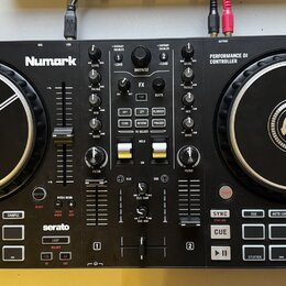 Černý DJ kontrolér značky Numark s nápisem PERFORMANCE DJ CONTROLLER a označením MIXTRAK PRO FX. Zařízení obsahuje dva velké jog-kola s bílým logem u…