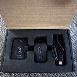 V kartonové krabici s pěnovým vložkem jsou dvě černé bezdrátové jednotky a černý USB kabel. Na levé jednotce je nápis JOYO, JW-07 RECEIVER a na pravé…