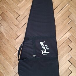 Černý poloměký obal na kytaru z textilního materiálu. Na přední straně je bílý nápis Gibson USA. Obal má zipovou kapsu a přenosný popruh.
