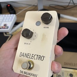 Kompaktní efekt pedál v krémové barvě s dvěma černými ovládacími knoflíky. Na pedálu jsou nápisy VOLUME, BREAK-UP a v dolní části značka DANELECTRO®…