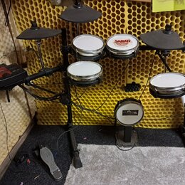 Elektronická bicí souprava s černým rámem a gumovými pady. Na jednom z padů je viditelné logo SABIAN. Souprava obsahuje pět padů, tři činely a ovláda…