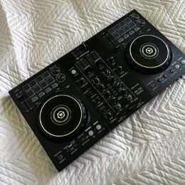 Černý DJ kontrolér s dvěma jog-koly a centrálním mixážním sekcí. Na horní části je bílé logo Pioneer DJ a v pravé části nápis DDJ-400. Povrch přístro…