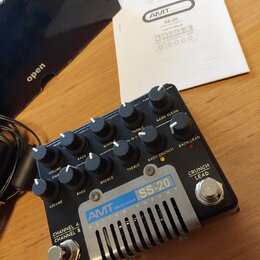 Černý kytarový předzesilovač s kovovým chladičem v dolní části. Na přístroji je modré logo AVIT Electronics a nápis SS-20 GUITAR PREAMP. Zařízení obs…