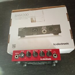Červený basový zesilovač s nápisy BAM200, INPUT, GAIN, BASS, MIDDLE, TREBLE a MASTER. Na předním panelu je logo tc electronic a text CLASS-D BASS AMP…