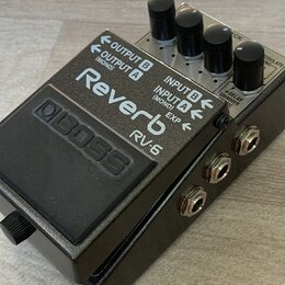Kytarový efekt pedál v šedém kovovém provedení s černým spínacím pedálem. Na horní části je bílý nápis Reverb a model RV-6, v levé části je vyražené…