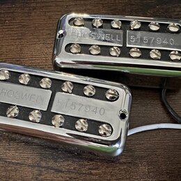 Dva chromované humbuckery s černými cívkami a viditelnými póly. Na kovových krytech je vyražen nápis ROSWELL a číslo 5157940. Z obou snímačů vedou el…