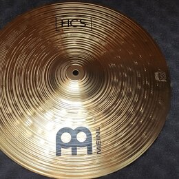 Zlatý kovový činel s výrazným žebrováním po celém povrchu. Na horní části je nápis HCS v rámečku a ve spodní části velké logo M s nápisem MEINL. Na p…