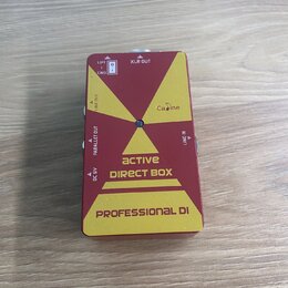 Červená kompaktní DI box s žlutými grafickými prvky. Na zařízení jsou nápisy „Ca dine“, „active DIRECT BOX“ a ve spodní části „PROFESSIONAL DI“. Jsou…