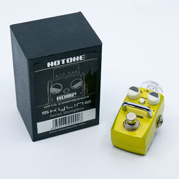 Žlutý efekt pedál s kovovým šasi a stříbrným spínacím tlačítkem. Na horní straně jsou dva bílé ovládací knoflíky a jeden průhledný knoflík s nápisy C…