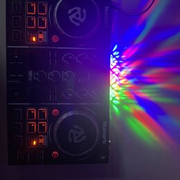 Černý DJ kontrolér s dvěma jog-koly a ovládacími prvky. Na přístroji jsou viditelný nápisy Numark, PARTY MIX a čísla 1 a 2. Některá tlačítka jsou pod…