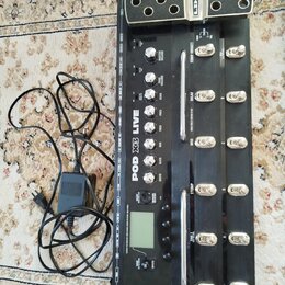 Černý kytarový procesor s kovovými spínači a ovládacími knoflíky. Na přístroji jsou nápisy LINE 6, POD X3 LIVE a označení sekcí jako COMP (BOOST), DE…